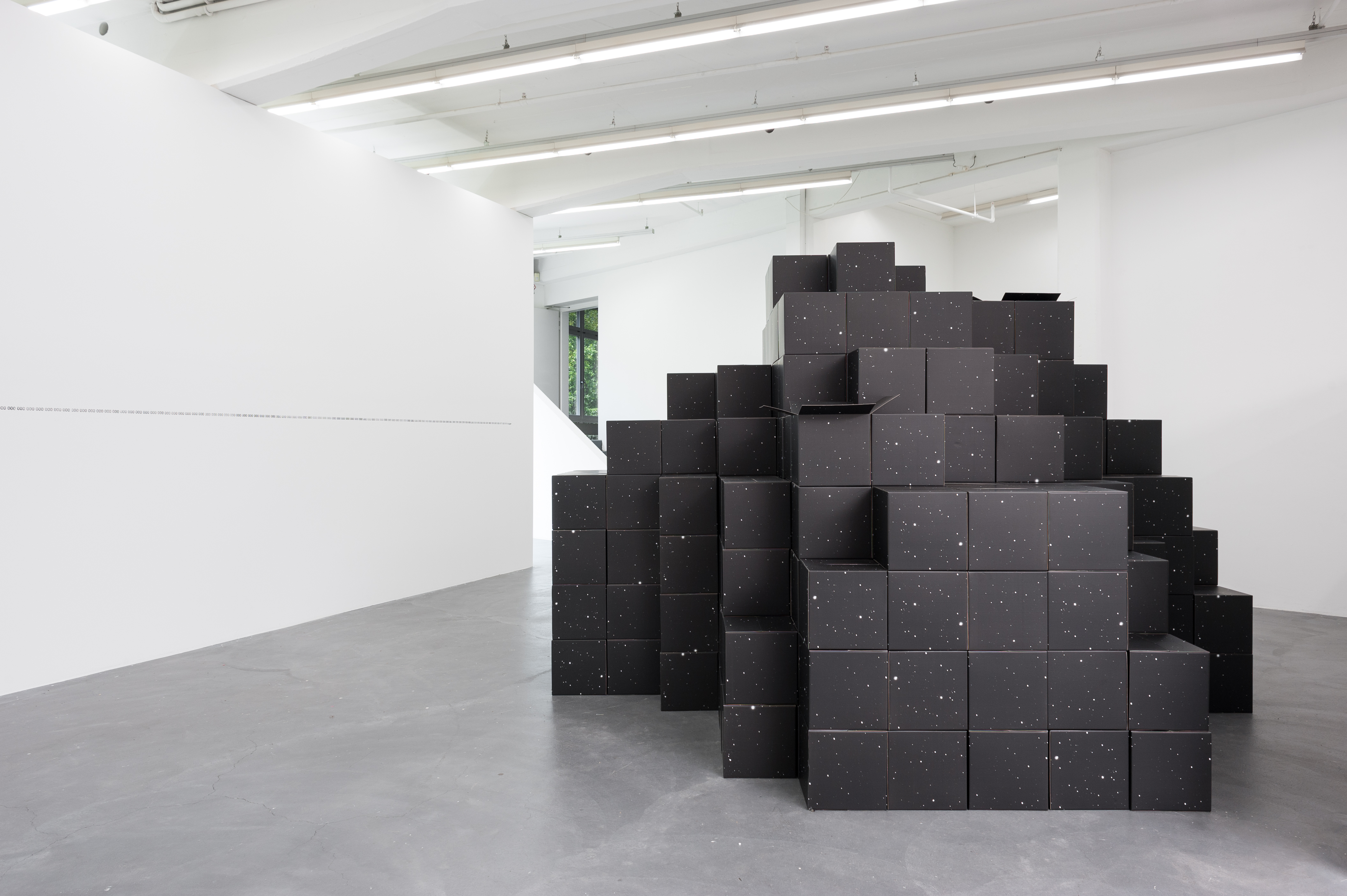 Folded into One, carboard boxes printed on both sides, variable dimensions (each unit 30 x 30 x 30 cm), 2012. Exhibition view at Kunsthaus Baselland, photo: Emile Ouroumow, 2015